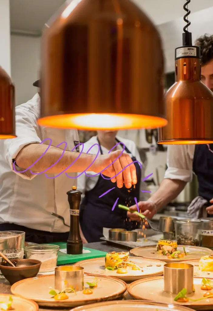 Cuisine de restaurant où l’on voit la main d’un cuisinier en train d’assaisonner des plats devant son équipe. À l’image d’un chef qui se perfectionne et réapprend continuellement, les équipes de votre entreprise vont apprendre à apprendre pour booster leurs compétences et leur performance, grâce à Prefera.