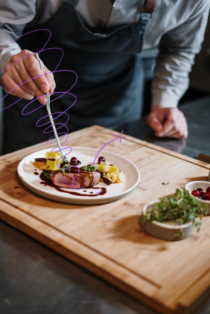 Gros plan sur les mains d'un cuisinier en train de dresser une belle assiette contenant un pavé de bœuf et des légumes. À la manière d'un grand chef qui promeut la gastronomie tout en maîtrisant son budget, Prefera vous apprend à mettre en avant vos offres et à défendre vos marges.